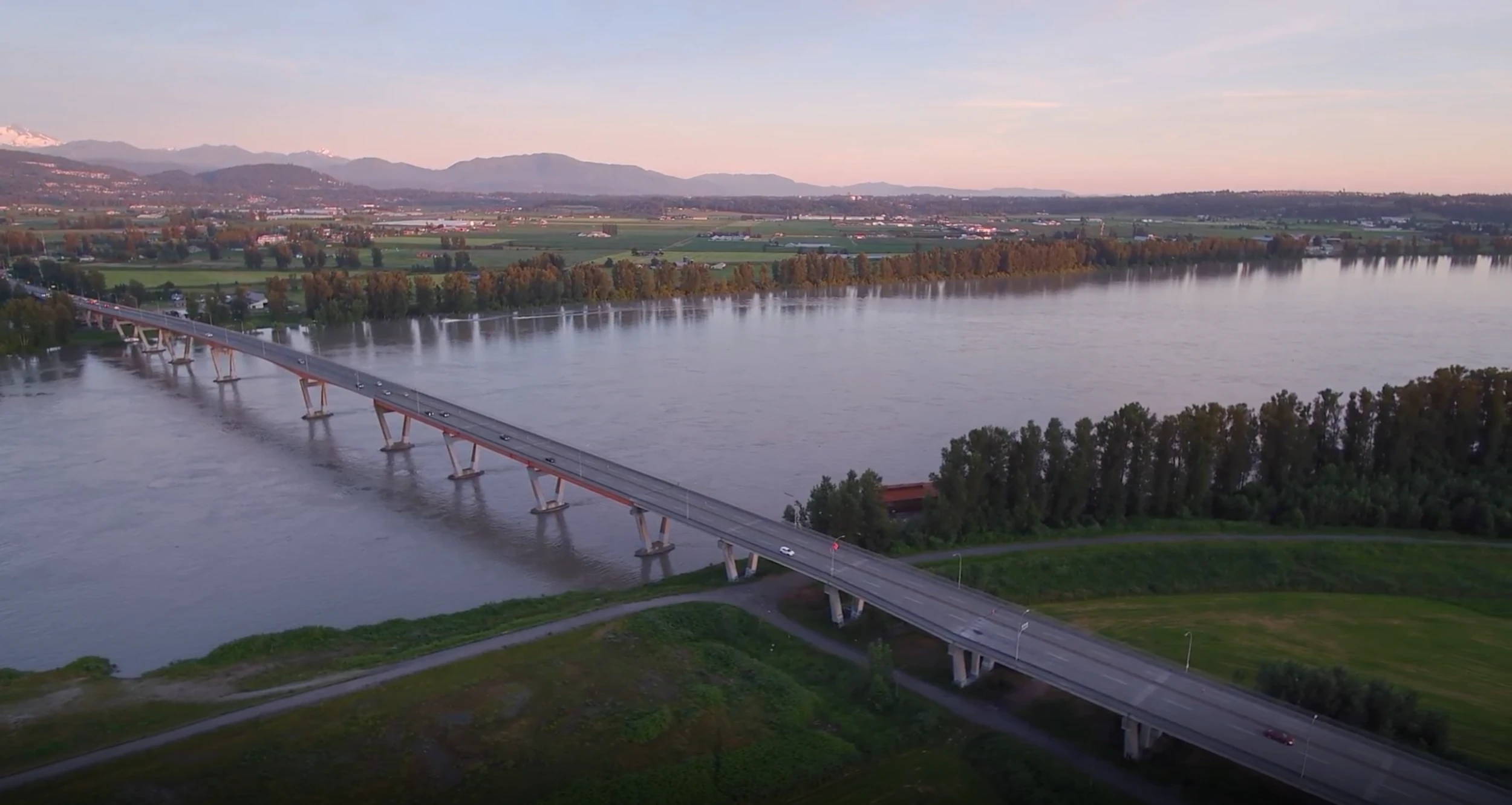 Bridge over water overview at sunset with mountains in the background